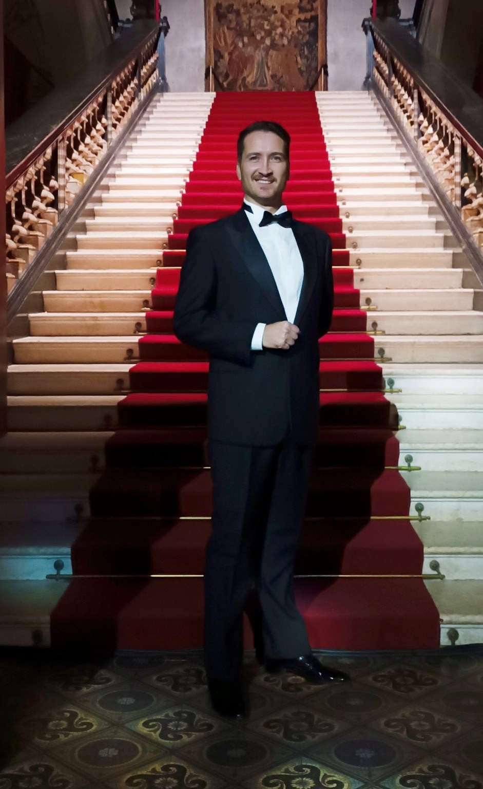 Francesco Tuppo in smoking sulla scalinata con tappeto rosso